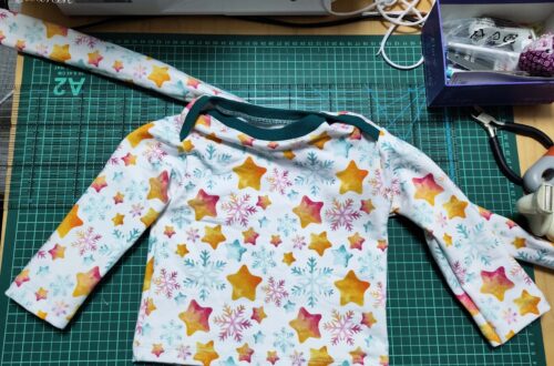 fertiges Set aus Baby Sweatshirt und Drahthaarband. weißer Stoff mit buntem Sternendesign